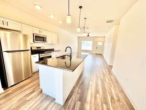 A modern kitchen with a stainless steel refrigerator and wooden flooring.at Concord Crossing, Lafayette, IN 47909  