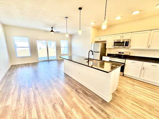 A kitchen with white cabinets and a black countertop.at Concord Crossing, Lafayette  