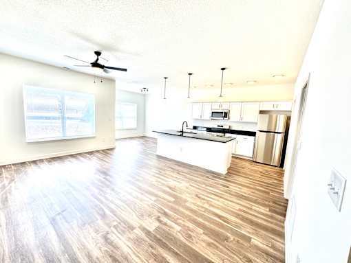 A kitchen with a wooden floor and white walls.at Concord Crossing, Lafayette Indiana  