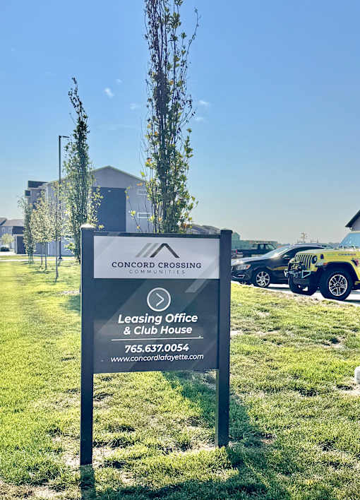 A sign for Concord Crossing Communities Leasing Office and Club House is displayed in a grassy area.