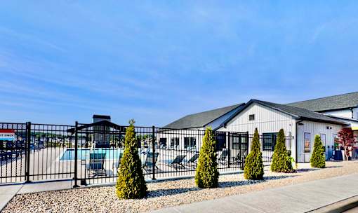 A building with a black fence and a few trees in front.