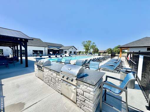 A row of outdoor grills are lined up on a patio.