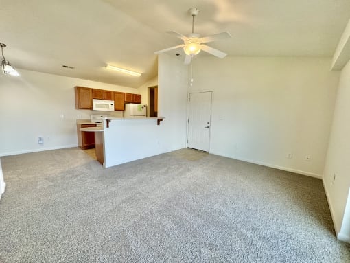 an empty living room with a ceiling fan and a kitchen  at Hawthorne Properties in Lafayette, IN 47905