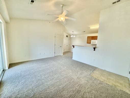 the living room and kitchen of an empty house with a ceiling fan  at Hawthorne Properties in Lafayette, IN 47905