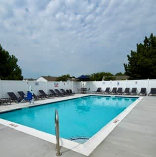 A pool with a person in a blue jacket standing by it.