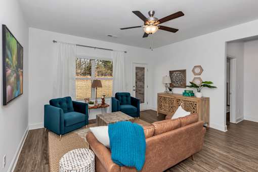 A living room with a brown couch and blue chairs.