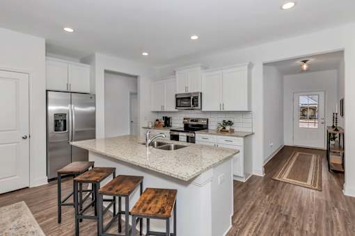 A kitchen with white cabinets and a granite countertop.
