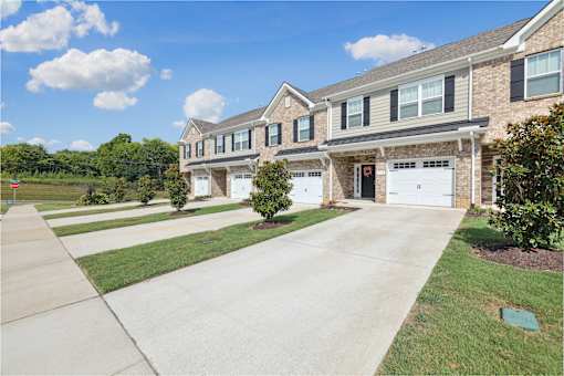 A large house with a driveway in front.