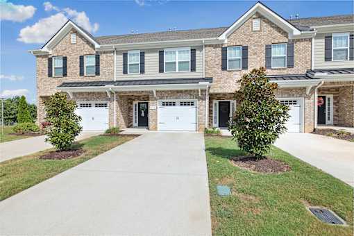 A large house with a driveway in front.