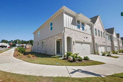 Elegant townhome exterior with pristine landscaping and driveway