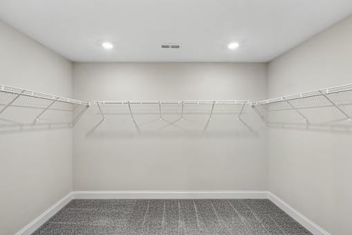 Empty room with white walls and grey carpet.