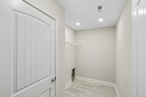 A white door is open to a room with a tiled floor.
