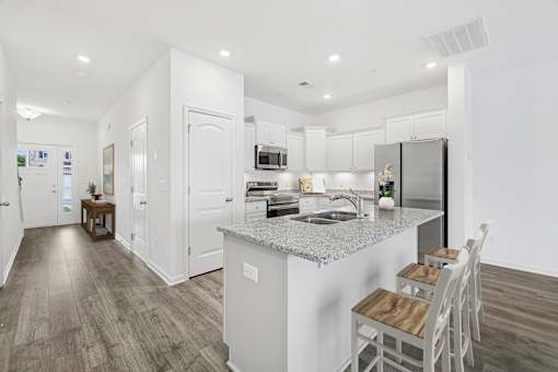 A modern kitchen with a large island and white cabinets.