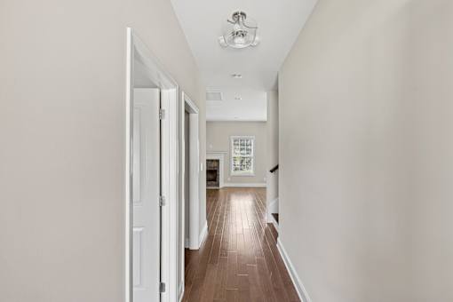 A long hallway with a door on the left and a window on the right.