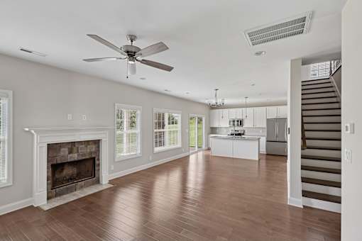 A spacious living room with a fireplace and hardwood floors.