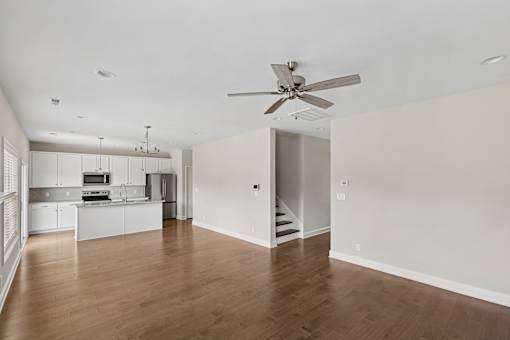 A spacious room with a ceiling fan and wooden flooring.