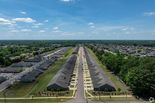 A long row of houses are lined up on a street.