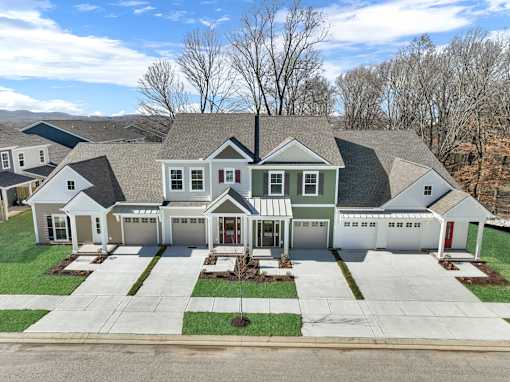 A large, two-story house with a garage and a driveway.