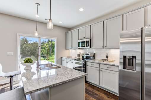 A modern kitchen with granite countertops and stainless steel appliances.