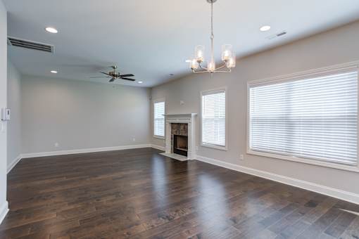 A spacious room with a fireplace and a chandelier.