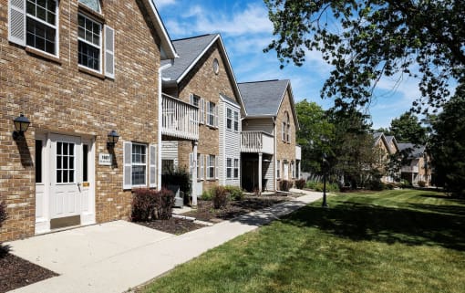 a brick house with a white door and a sidewalk
