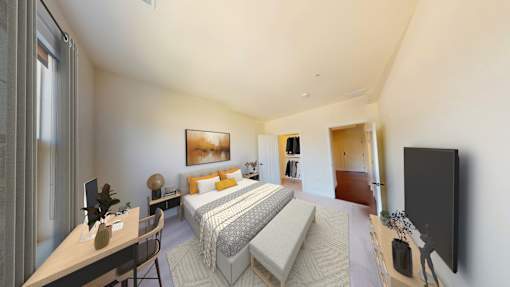 A bedroom with a bed, desk, and chair.