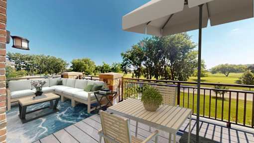 A patio with a white umbrella and a table with chairs.