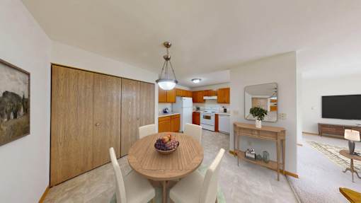 A dining room with a wooden table and chairs.