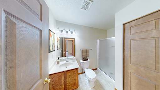 A bathroom with a toilet, sink, and mirror.