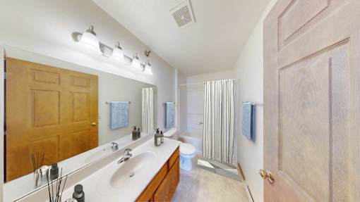 A bathroom with a sink, mirror, and towel rack.