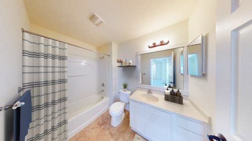 A bathroom with a toilet, sink, and shower.