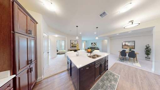 A kitchen with dark wood cabinets and a white countertop.