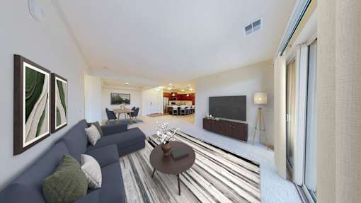 A living room with a blue couch and a painting on the wall.