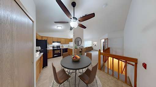 A kitchen with a table and chairs in the middle of the room.