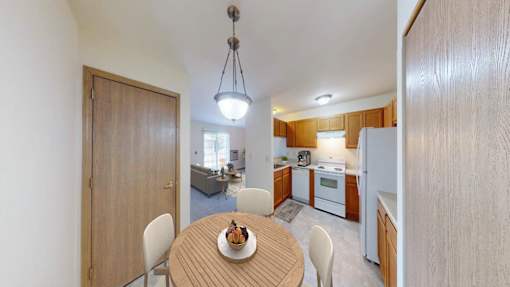 A kitchen with a table and chairs in the middle of the room.