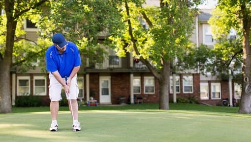 a man in a blue shirt is playing golf