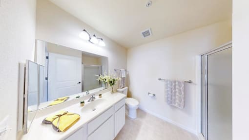 A bathroom with a white counter and a yellow towel.