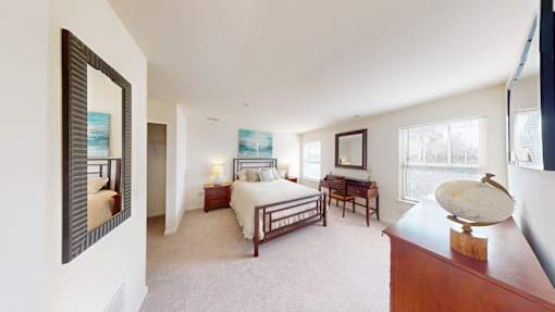 A bedroom with a bed, desk, and chair.