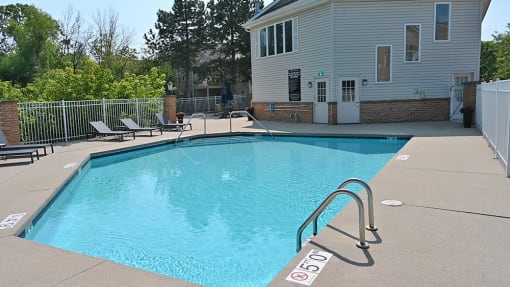 a swimming pool with a house in the background