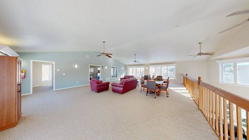 A spacious living room with a dining table and chairs.