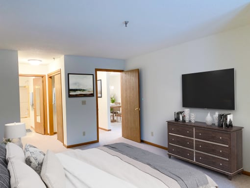 a bedroom with a bed and a dresser and a tv