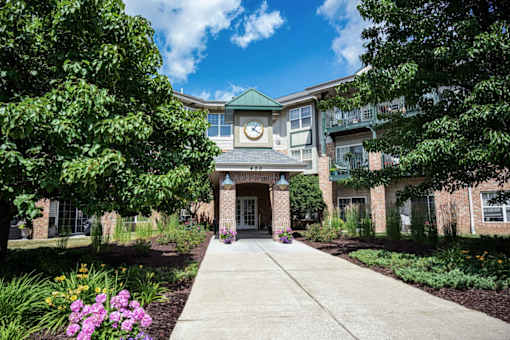 a sidewalk in front of a building with a clock on the front