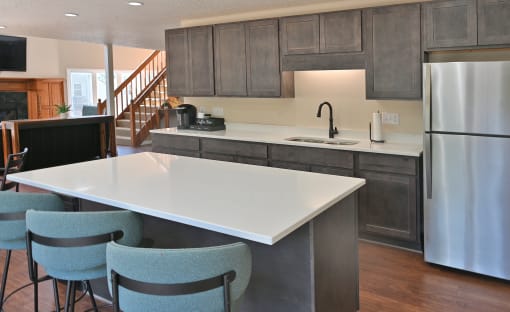 a kitchen with a white counter top and a stainless steel refrigerator