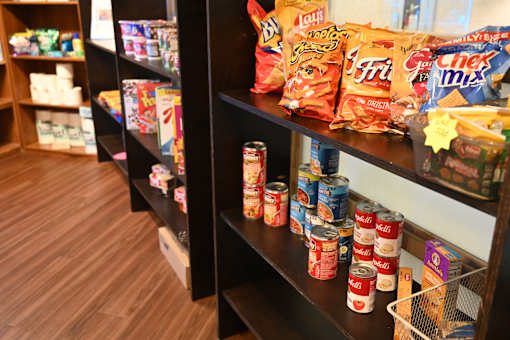 A shelf of canned goods and snacks.