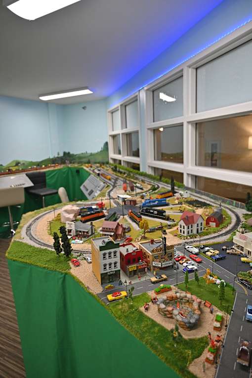 A model of a town with buildings, roads, and vehicles is displayed on a table.