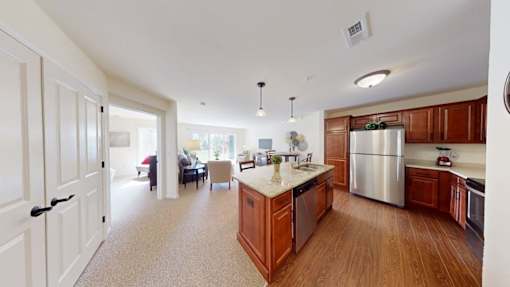 A kitchen with wooden cabinets and a stainless steel refrigerator.