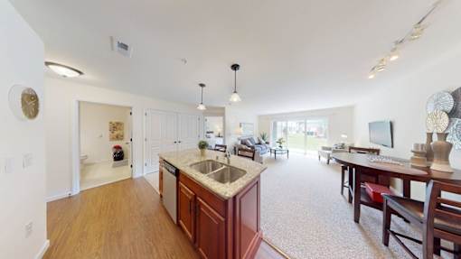 A kitchen with wooden cabinets and a large island in the middle.