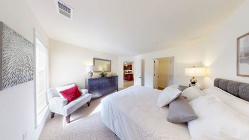 A bedroom with a large bed and a couch.