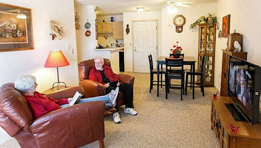 two people sitting in a living room watching tv