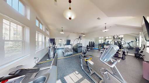 A gym with treadmills, elliptical machines, and other exercise equipment.